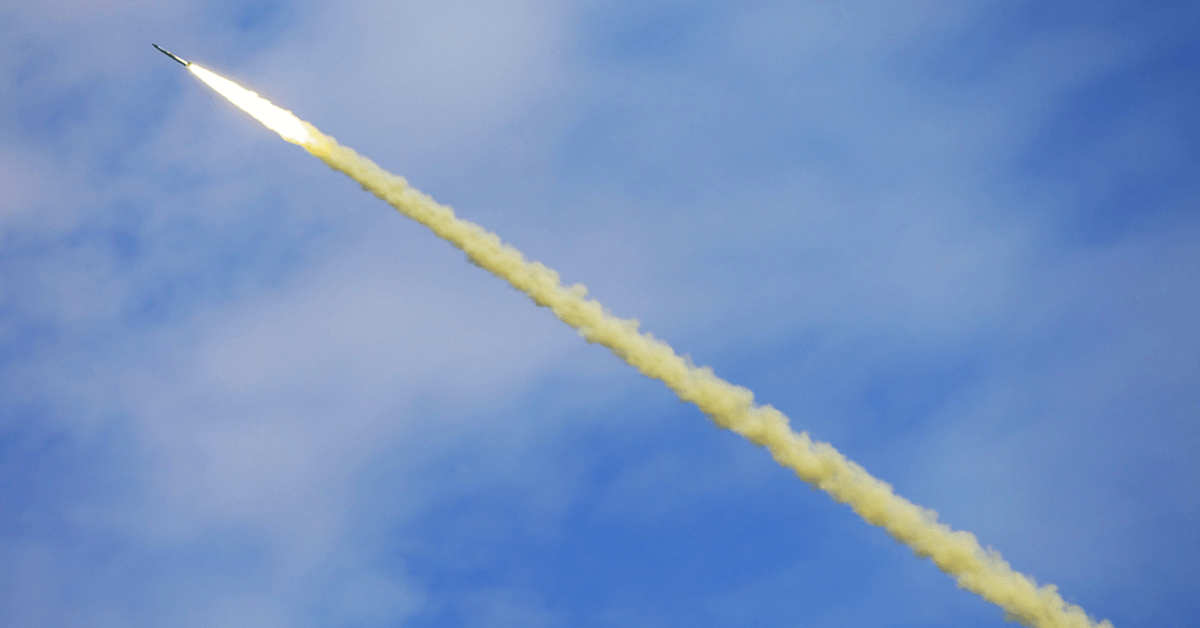 A missile shoots into the atmosphere, trailed by smoke.