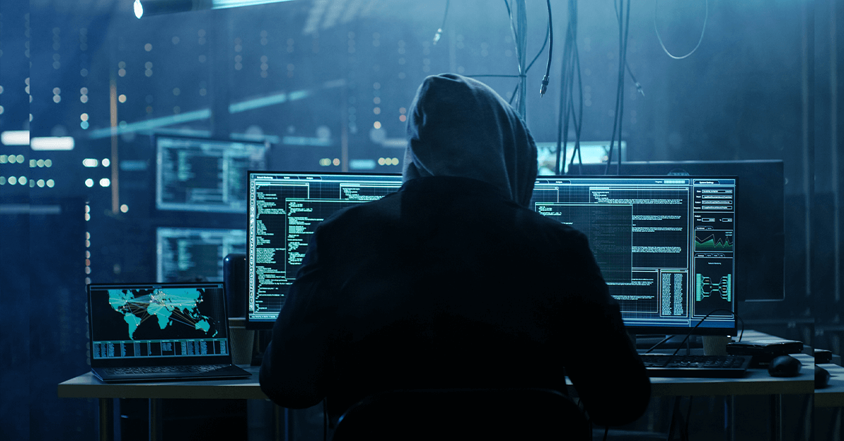 Cybercriminal hunched at computer